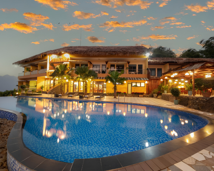 Puluong Ecoluxe resort exterior with pool at dusk.