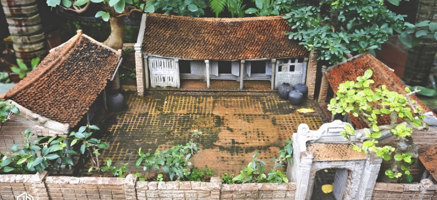Traditional miniature Vietnamese courtyard scene surrounded by greenery.